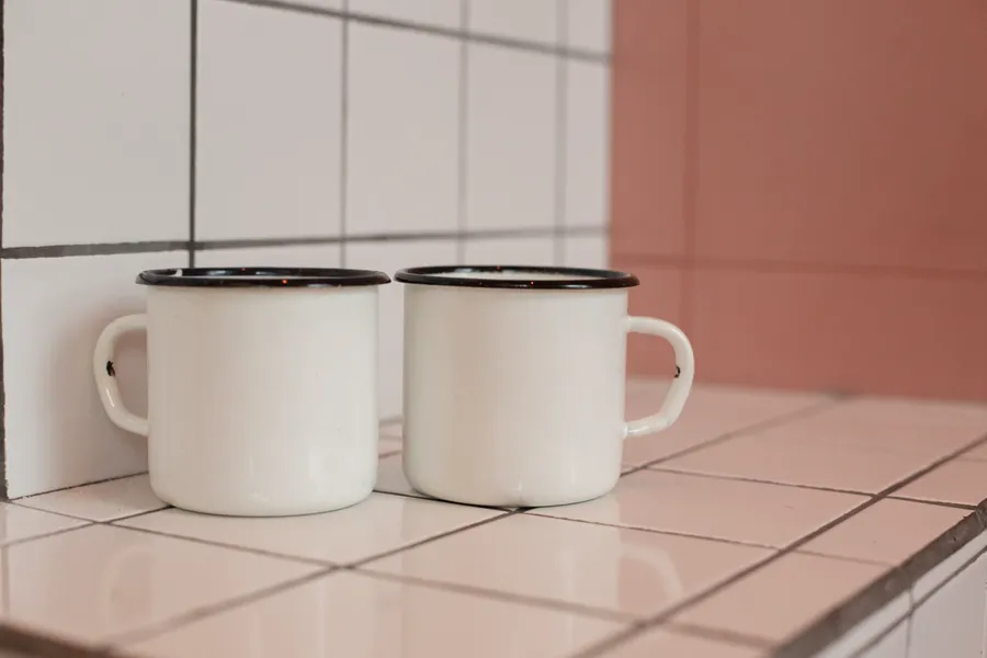 Two enamel vessels on a tiled surface